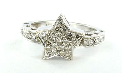 un gros plan d'une bague en forme d'étoile sertie de diamants sur fond blanc