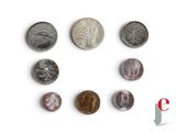 several different coins are arranged in a row on a white surface