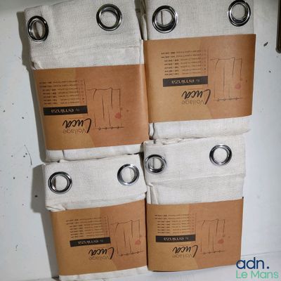 four pairs of white towels sitting on top of a white counter