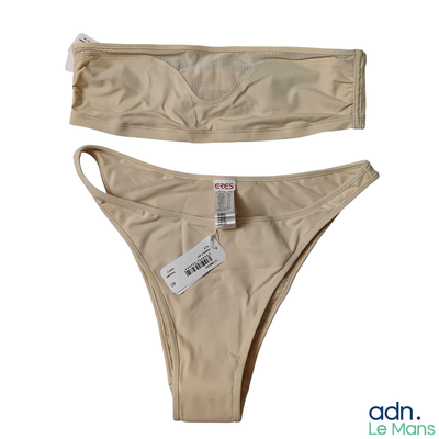 une paire de bikinis beige clair avec leurs étiquettes, sur fond blanc