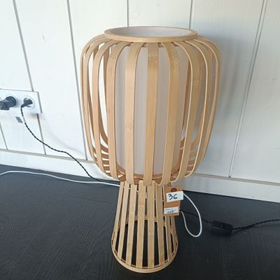 une lampe en bois posée par terre