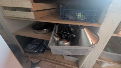 une étagère avec des casseroles et des poêles dans une cuisine