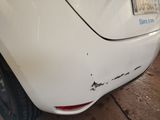 the rear end of a white car with a sticker on it ' s bumper