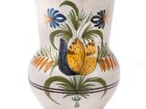 a white vase with a floral design on it