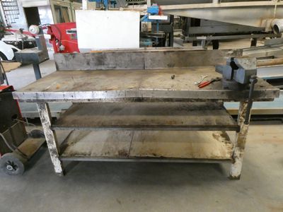 un établi au milieu d'un atelier rempli d'outils