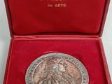 a close up of a red box with a silver medal in it
