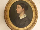 portrait d'une femme vêtue d'une robe noire et d'une chemise à col blanc