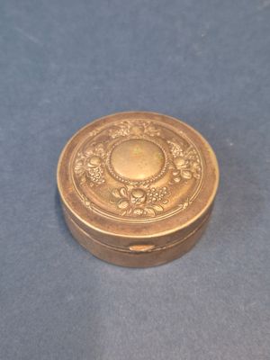 l'image d'une petite boîte dorée posée sur un fond bleu