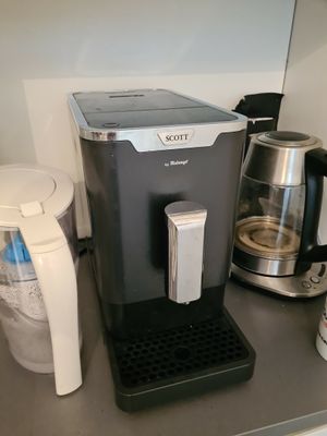 une cafetière et une verseuse posées sur le plan de travail de la cuisine