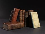 several old books are stacked on top of each other on a table