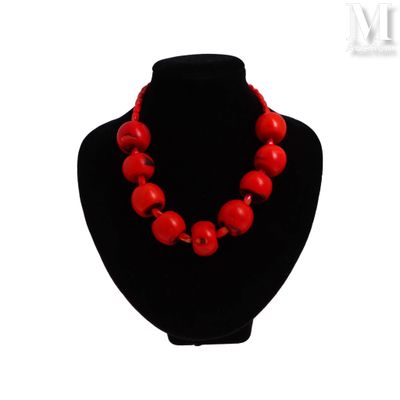 un gros plan d'un collier orné de perles rouges sur un mannequin