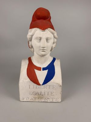 statue of a woman with a red hat and a blue ribbon around her neck