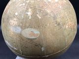 an old globe on a pedestal on a black background