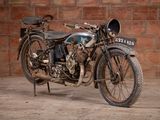 a old motorcycle that is parked in front of a brick wall