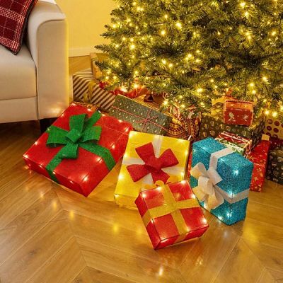 un sapin de Noël avec des cadeaux à ses pieds dans un salon