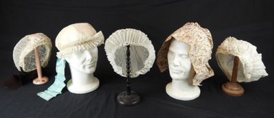 Plusieurs chapeaux sont alignés sur une tête de mannequin