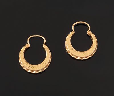 a pair of gold hoop earrings on a black background