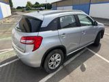 the back end of a silver suv parked in a parking lot