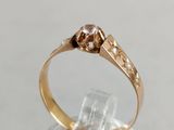 a close up of a gold ring with a diamond on top