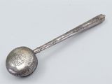 a silver spoon with a metal handle on a white surface