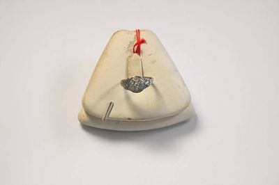 un petit objet blanc auquel est attachée une ficelle rouge