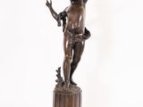 bronze statue of a boy holding a bird on a pedestal