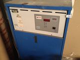 a blue and white machine sitting in a room next to a wall