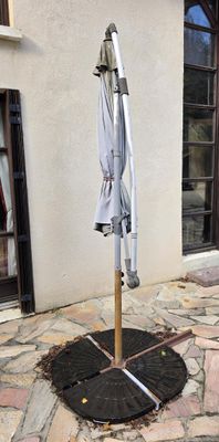 un parapluie fixé à un mât à l'extérieur d'un bâtiment