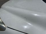 a close up of a car ' s hood with a dent in it
