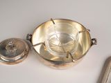 a silver plate and a mirror on a white table