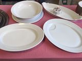 de nombreuses assiettes et bols posés sur une table recouverte d'une nappe rose