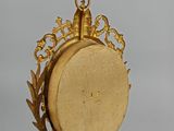 a gold clock that is hanging on a wall