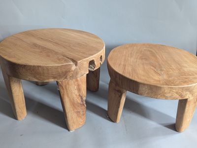 two wooden stools sitting next to each other on a gray surface