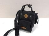 the small black bag is sitting on the table next to the strap