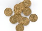 une pile de pièces d'or posée sur une surface blanche