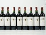 six bouteilles de vin sont alignées sur une surface blanche