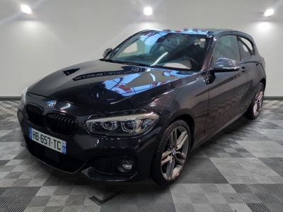 La BMW M140i noire est garée sur un sol à damier.