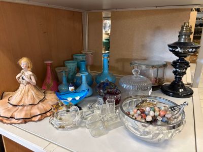 une étagère sur laquelle sont disposés de nombreux objets en verre et des vases