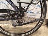 a close up view of a bicycle wheel with a sign in the background