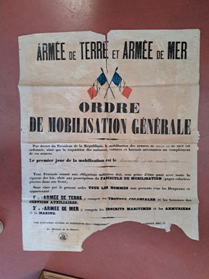 une affiche accrochée au mur d'un immeuble sur laquelle figure un drapeau français