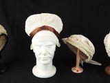 trois chapeaux sont alignés sur une tête de mannequin