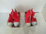 deux paires de Converse rouges exposées dans une vitrine