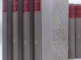 several books are lined up in a row on a white surface