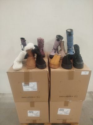 several pairs of shoes are stacked on top of boxes in a room