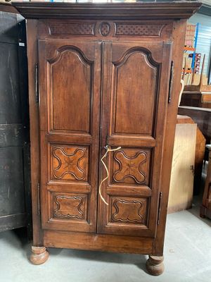 a wooden armoire with carvings on it in a room