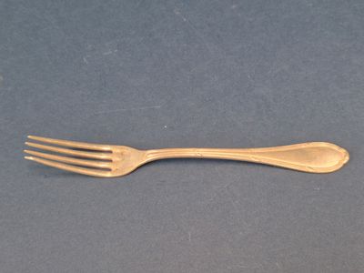 une fourchette en or et une cuillère en argent posées sur une table