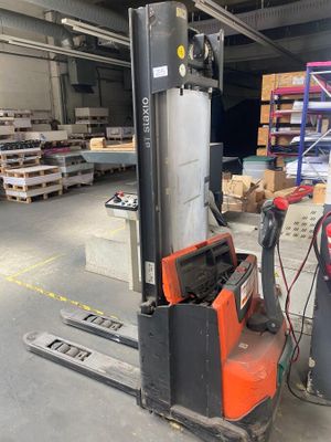 un chariot élévateur dans un entrepôt, avec des palettes en arrière-plan