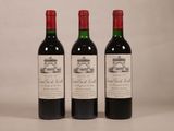trois bouteilles de vin rouge posées côte à côte sur une table
