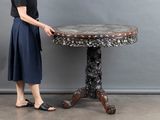 a woman that is standing next to a table