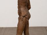 an old wooden statue of a man with a hat on his head